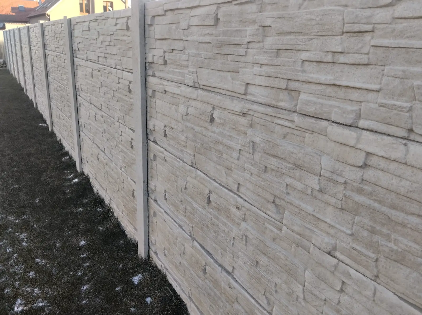 Moderní šedý betonový plot s čistým rovným zakončením v Banticích.