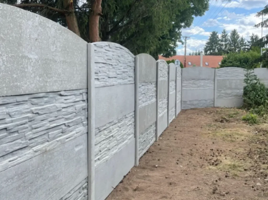 Šedý betonový plot s kombinovaným vzorem a obloukovým zakončením realizovaný v Moravském Krumlově.